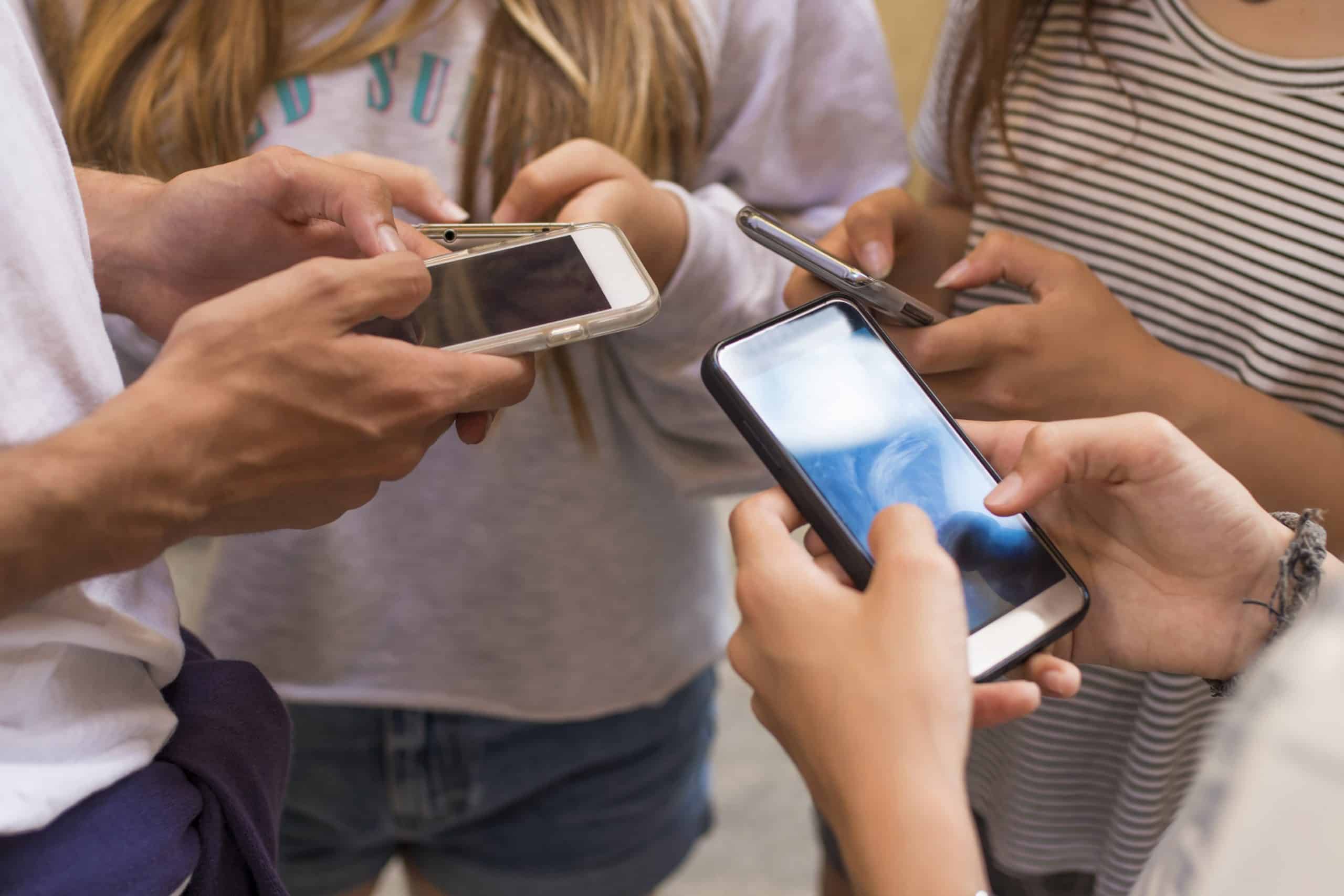 Teens holding smart phones
